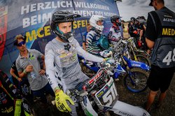 Das Bild zeigt Motocrossfahrer vor dem Start umringt von Presse und Teammitgliedern